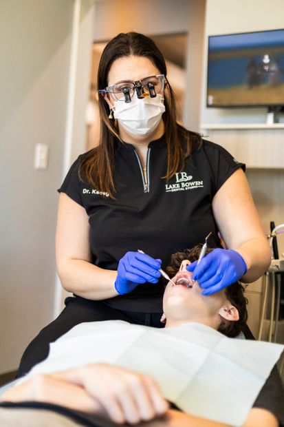 A young patient at Lake Bowen Dental Studio smiling while sitting in a dental chair wearing a protective bib