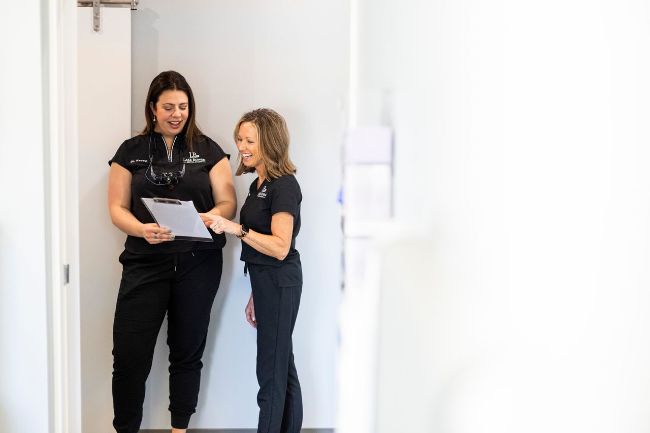 Lake Bowen Dental Studio team members reviewing patient information together in the office hallway